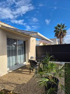 een terras met een tafel en stoelen voor een huis bij Chez Carisa in Puilboreau