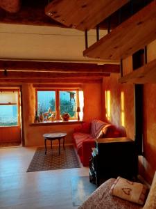 un soggiorno con un divano rosso e un tavolo di Eco-gîte panoramique face aux volcans avec ateliers couture bohème en option a Champagnac-le-Vieux Altre 34 foto