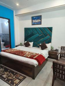 ein Schlafzimmer mit einem großen Bett mit einer blauen Wand in der Unterkunft Shiv Guest House in Masuri