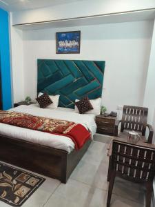 ein Schlafzimmer mit einem großen Bett mit blauem Kopfteil in der Unterkunft Shiv Guest House in Masuri
