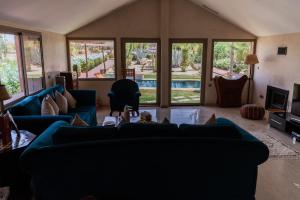 SUMAHAN SUITES & SPA في مراكش: غرفة معيشة مع أرائك زرقاء وتلفزيون