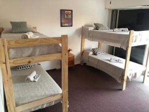 een kamer met 3 stapelbedden en een spiegel bij Che in Necochea