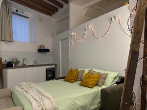 a room with a bed with yellow pillows on it at Cà du Local in Arenzano