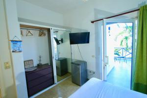 a bedroom with a dresser and a sliding glass door at Brisa de Alma Guesthouse in Bayahibe
