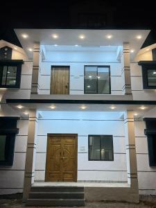 un edificio blanco con puerta y ventanas de madera en Royal Casa Resort Diveagar, en Borlai Panchaitan 4 fotos más