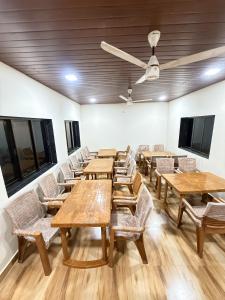 una fila de mesas y sillas en una habitación en Royal Casa Resort Diveagar, en Borlai Panchaitan