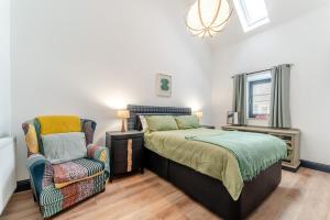 a bedroom with a bed and a chair at 5 Bed in Galston oc-s33451 in Galston