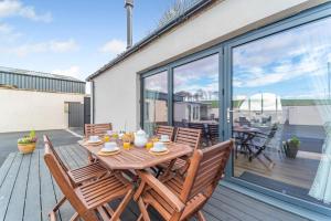 a wooden table with chairs on a wooden deck at 5 Bed in Galston oc-s33451 in Galston