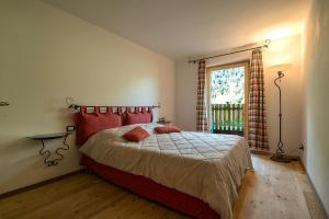 テーゼロにあるCasa Fam.Barboliniのベッドルーム1室(赤い枕のベッド1台、窓付)