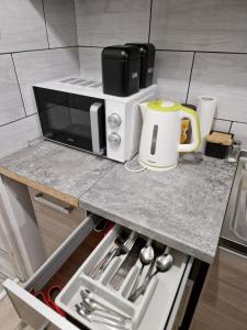 Un microondas colocado encima de una encimera de cocina. en SAWAGO przytulne mieszkanie u Gosi Lekowo Ciechanów,  16 fotos más