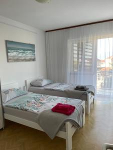a bedroom with two beds and a window at Casa Estancia Apartment in Njivice