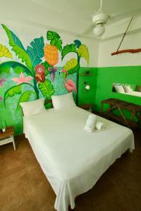 a bedroom with a white bed with a colorful wall at Brisa de Alma Guesthouse in Bayahibe +136 photos