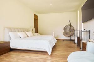 1 dormitorio con 1 cama blanca grande y ventilador en La Malenita casa en Amanalco, en Amanalco de Becerra 34 fotos más