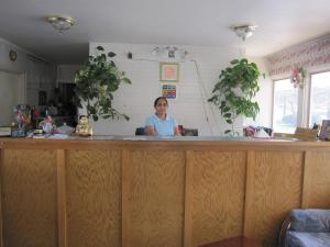 una mujer parada detrás de una barra en una cocina en Budget Inn Fairport en Fairport