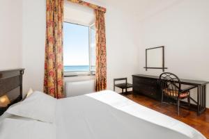 a bedroom with a bed and a desk and a window at 331 - Lord Nelson Appartamento Fronte e Vista Mare 4 in Chiavari