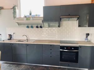 a kitchen with gray cabinets and a sink and a stove at Casa Água in Lamas