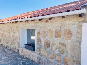 a stone wall with a window on a building at Casa Água 