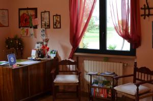a room with a desk and two chairs and a window at Agriturismo Dondino in Cavriana