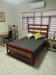a bedroom with a wooden bed with two pillows at Renta de habitación equipada para ejecutivos in Saltillo