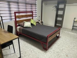 a bedroom with a wooden bed with green pillows at Renta de habitación equipada para ejecutivos in Saltillo