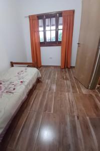 una camera da letto con un letto e un pavimento in legno di Cabaña Benitto a Potrero de Garay