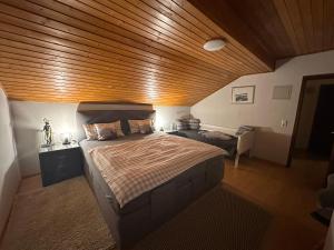 een slaapkamer met een groot bed met een houten plafond bij Apartment Rosi SECONDO in Reisbach