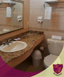 uma casa de banho com um lavatório, um WC e um espelho. em Hotel Plaza Maria em Catacamas