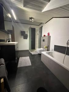 een badkamer met een bad, een toilet en een wastafel bij Apartment Rosi SECONDO in Reisbach +46 foto's