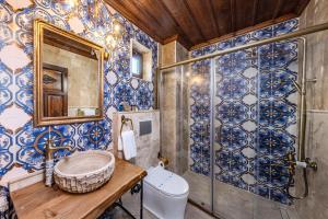un bagno con piastrelle bianche e blu sul muro di Erbelya Cappadocia House a Göreme