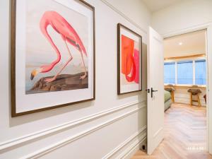 a hallway with two framed paintings on the wall at Ember at The Heim Residences in Manchester