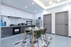 a dining room with a table and chairs in a kitchen at Tatiana’s Luxury Apartment in Nairobi