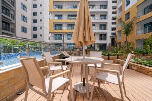 a patio with a table and chairs and an umbrella at Tatiana’s Luxury Apartment in Nairobi