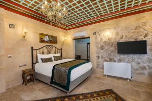 una camera da letto con un letto e una TV a schermo piatto di Erbelya Cappadocia House a Göreme