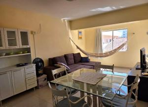 a living room with a glass table and a couch at Res Mariscal em Bombinhas in Canto Grande