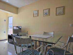 a dining room with a glass table and chairs at Res Mariscal em Bombinhas in Canto Grande