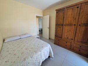 a bedroom with a bed and a large wooden cabinet at Res Mariscal em Bombinhas in Canto Grande