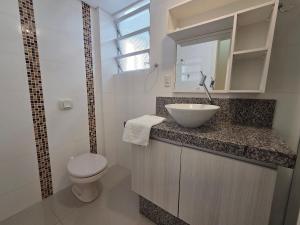 a white bathroom with a sink and a toilet at Res Mariscal em Bombinhas in Canto Grande +26 photos