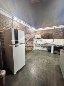 una cucina con un frigorifero bianco e un muro di mattoni di Chácara passárgada a Gravatá