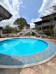 a large blue swimming pool in front of a house at Chácara passárgada in Gravatá