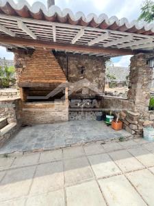 a stone fireplace in a stone wall with a wooden roof at Chácara passárgada in Gravatá