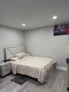 a bedroom with a bed and a white wall at Entire Private Studio JFK in Morris Park