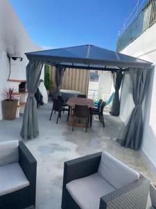 een terras met een tafel en stoelen onder een luifel bij Alvarenga House in Maia +19 foto's