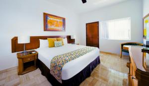 a hotel room with a large bed and a table at Ocean Breeze Nuevo Vallarta in Nuevo Vallarta