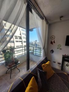 a living room with a couch and a large window at Departamento de Vacasiones Viña del Mar 2026 in Viña del Mar