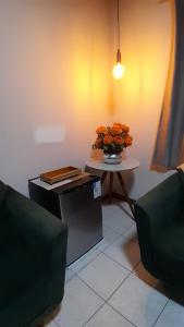 a room with a table with a vase of flowers on it at Natureza e sossego in Volta Redonda +3 photos