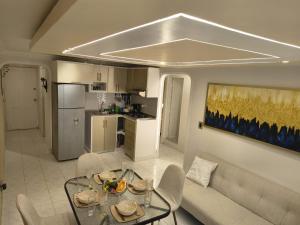 een keuken en een woonkamer met een tafel en een bank bij LuxeStay in Santa Marta in Gaira