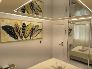 een badkamer met 2 schilderijen aan de muur en een spiegel bij LuxeStay in Santa Marta in Gaira +5 foto's