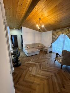 een woonkamer met een bank en een houten plafond bij Cabana Nys Escape in Bălceşti
