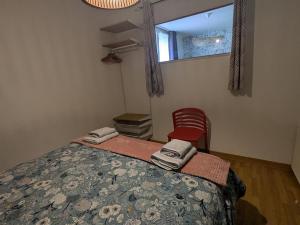 ein Schlafzimmer mit einem Bett, einem Fenster und einem Stuhl in der Unterkunft CAPUCiNE-Appartement Retro-chic & idéalement situé in Vitré + 6 Fotos