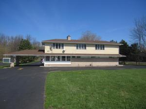 a large white house with a driveway in front of it at Budget Inn Fairport in Fairport
